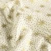 Christmas fabric made of cotton in cream color with a print of golden snowflakes 60679/051
